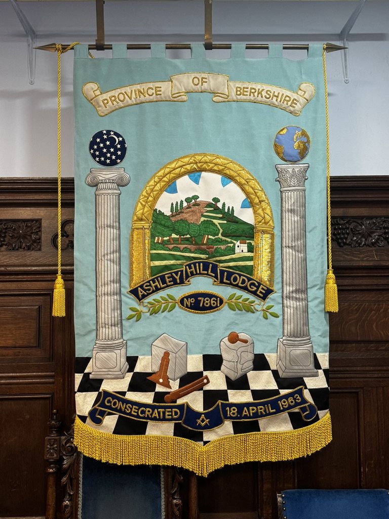 The Ashley Hill Lodge banner: Ashley Hill framed in a golden Norman arch between two pillars, over a chequered floor