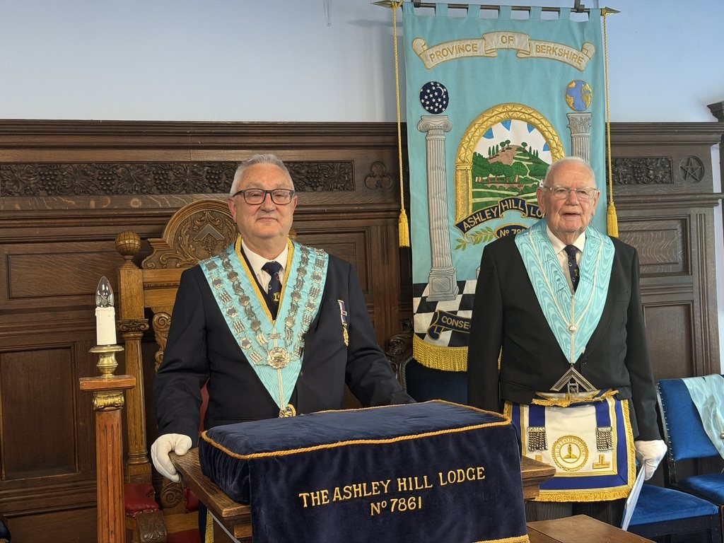 Two Brethren in regalia at the lodge pedestal